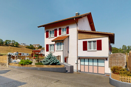 façade avec garage intégré, clôture, property visible, day time, et bardage en stuc