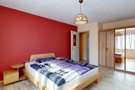 chambre avec cloison sèche, drywall, lumière naturelle, sol en finition bois, et wood finish floor