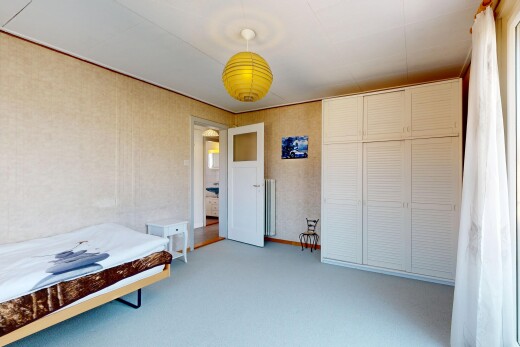 chambre avec placard, moquette, carpet, éclairage suspendu, et manufactured wall