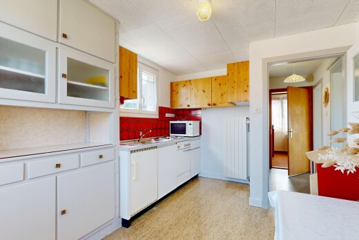 cuisine avec light countertops, plans de travail, light floor, radiateur, et white cabinets