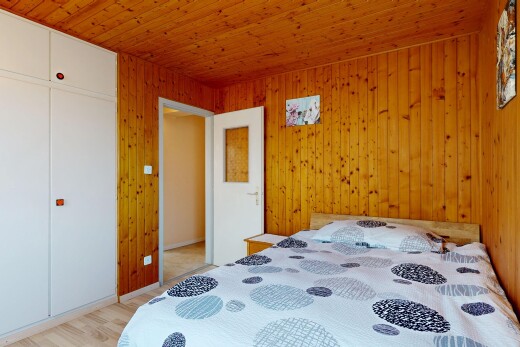 chambre avec sol en finition bois, wood finish floor, plafond en bois, wood ceiling, et placard
