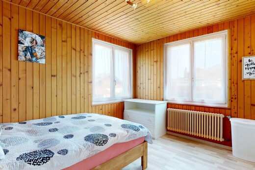 chambre avec radiateur, lumière naturelle, wood wall, mur en bois, et wood finish floor