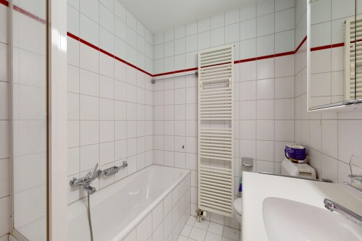 salle de bains avec chauffe-serviettes, mur en carrelage, tile wall, radiateur, et miroir