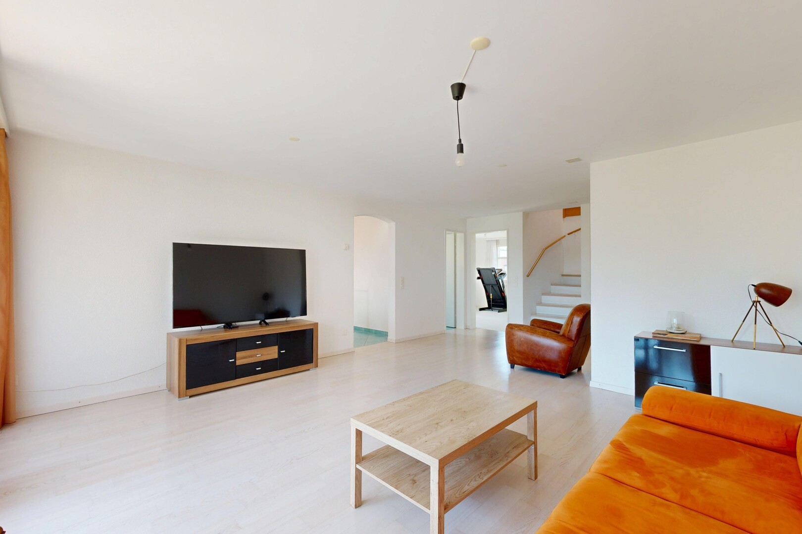 wohnzimmer mit gipskartonwand, drywall, treppen, fernseher, und holzfußboden