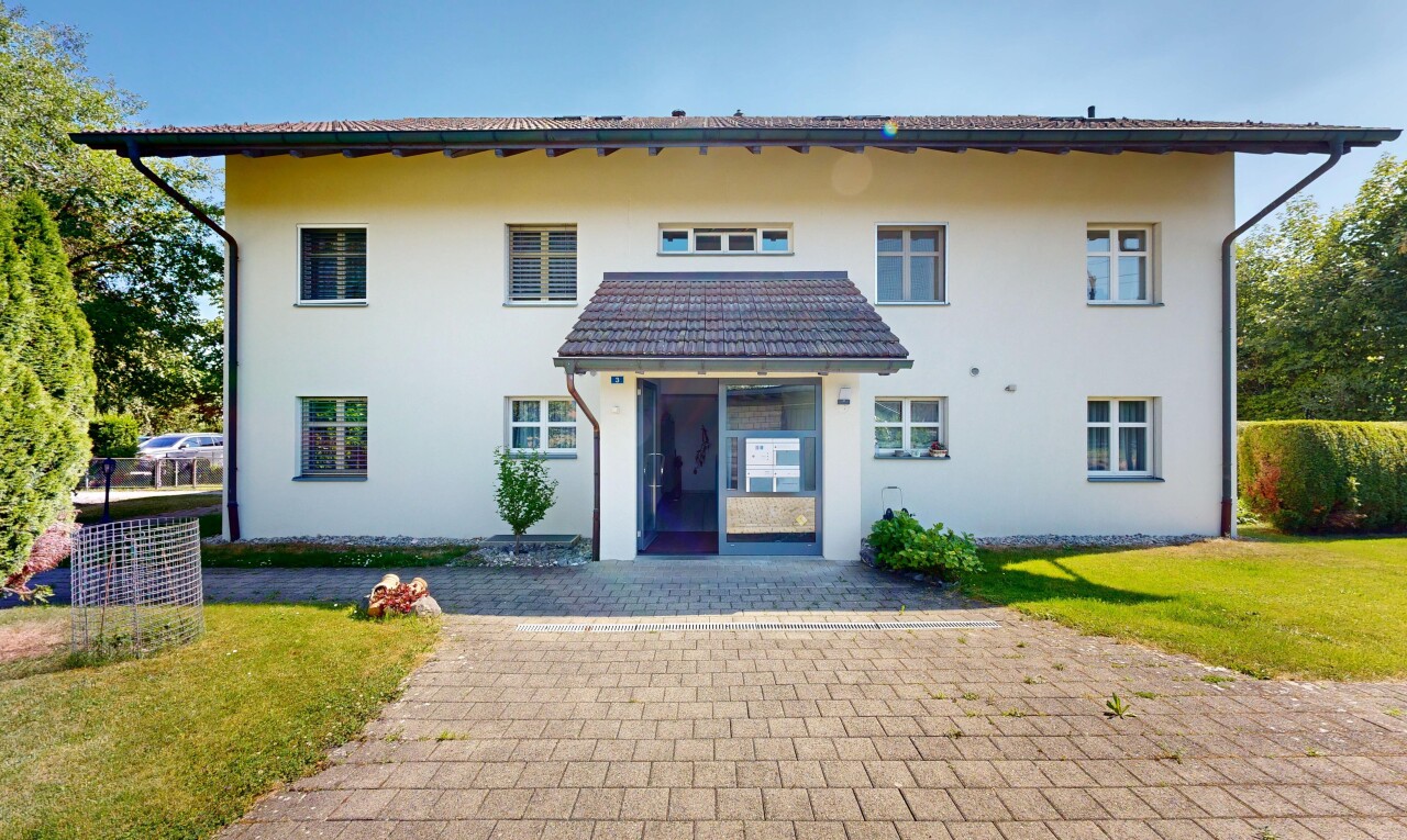 außenansicht mit day time, rasen, stuckverkleidung, property visible, und parkplatz