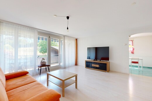 salon avec passages en arc, cloison sèche, drywall, télévision, et inside property