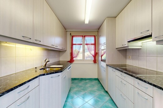 cuisine avec dark countertops, stone countertops, plans de travail en pierre, lumière naturelle, et natural light