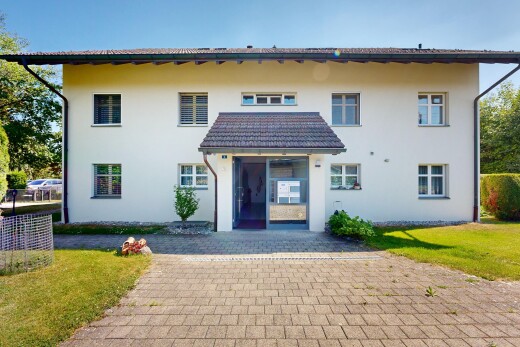 außenansicht mit day time, rasen, stuckverkleidung, property visible, und parkplatz