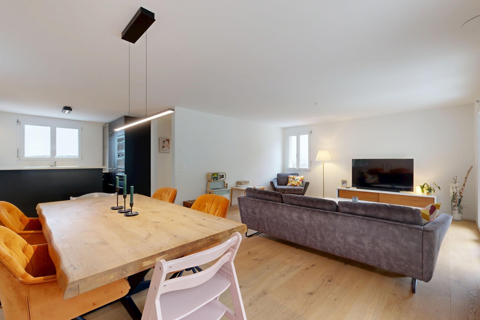 wohn- / esszimmer mit fernseher, wood finish floor, holzfußboden, inside property, und drywall