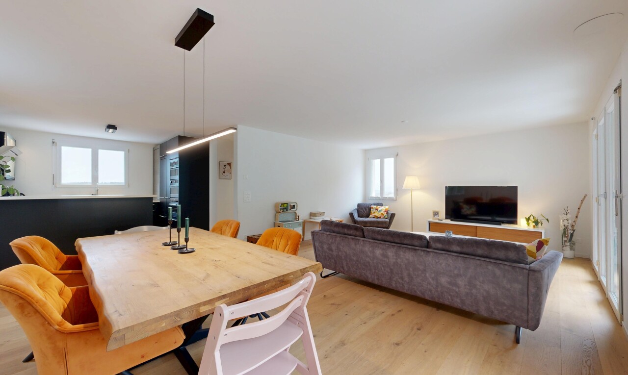 wohn- / esszimmer mit fernseher, wood finish floor, holzfußboden, inside property, und drywall