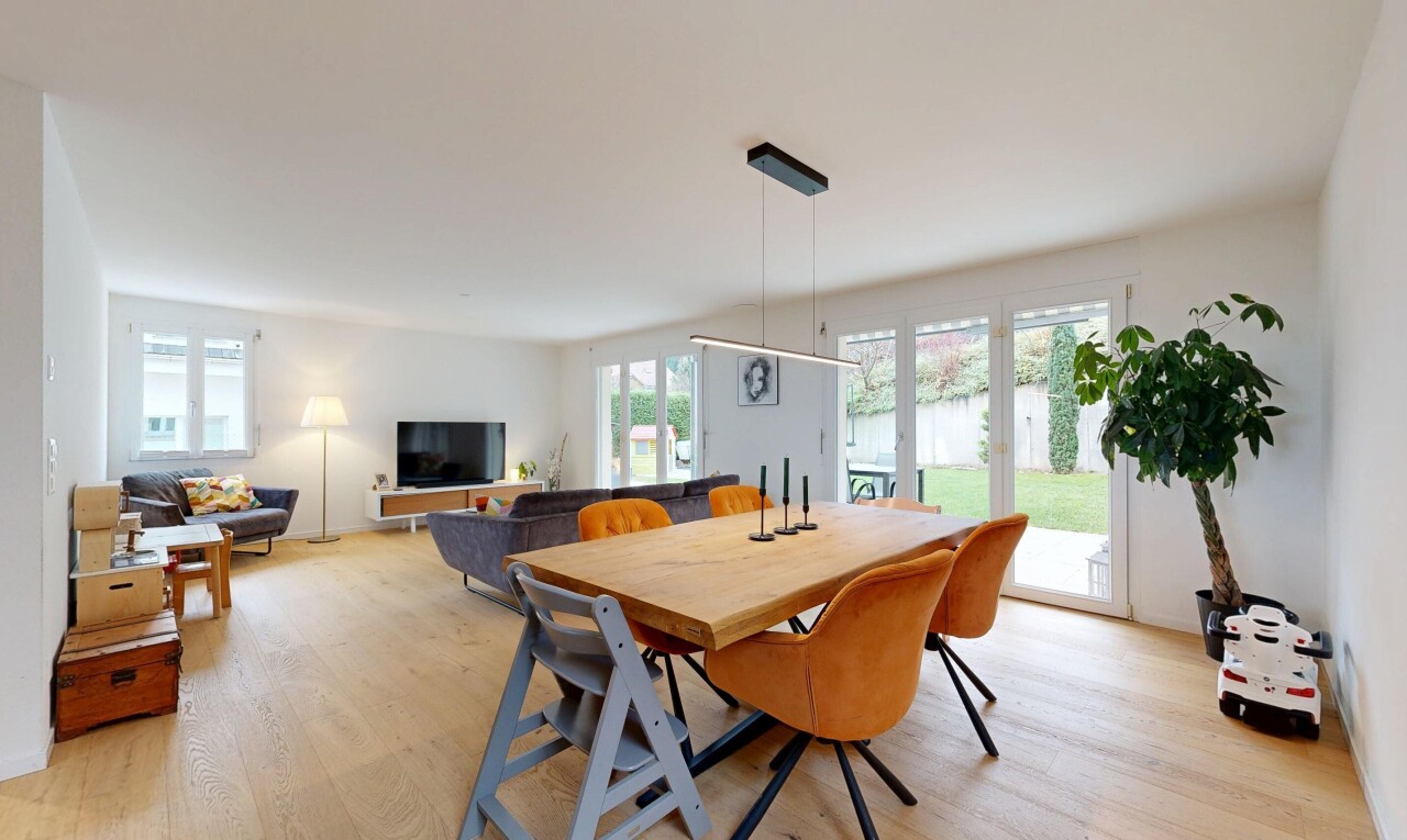 wohn- / esszimmer mit inside property, wood finish floor, holzfußboden, fernseher, und drywall