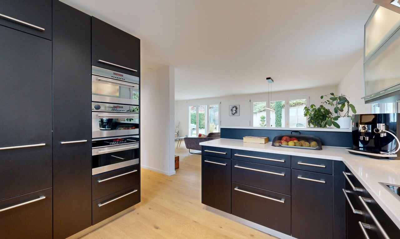 küche mit schwarze schränke, schränke mit flachen paneelen, pendelleuchte, wood finish floor, und holzfußboden