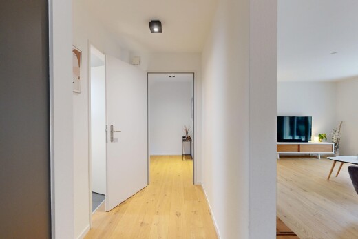 halle / korridor mit inside property, fernseher, wood finish floor, holzfußboden, und drywall