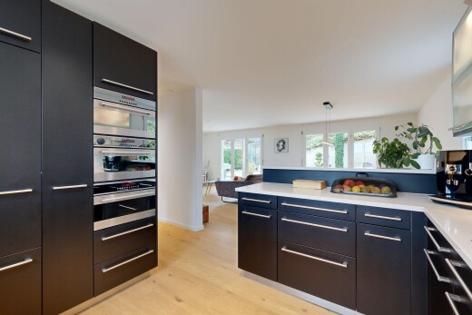 küche mit schwarze schränke, schränke mit flachen paneelen, pendelleuchte, wood finish floor, und holzfußboden