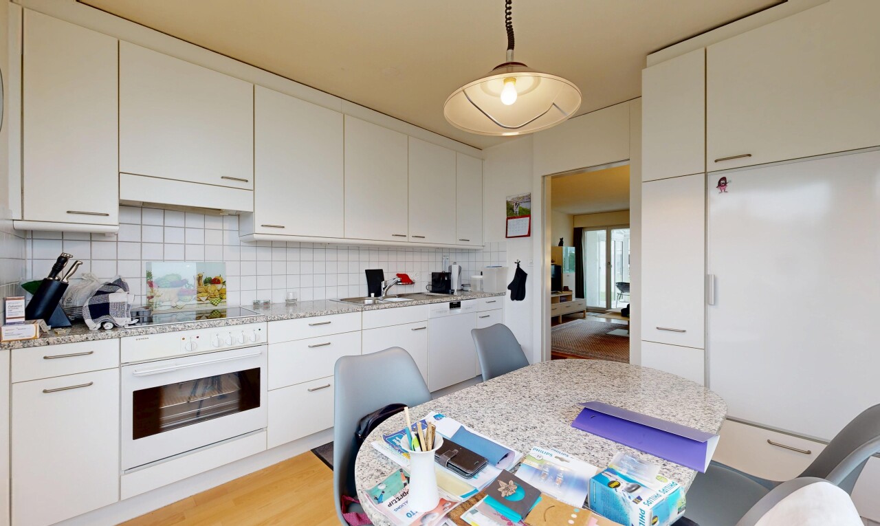 kitchen featuring white oven, white cabinets, decorative backsplash, and hanging light fixtures