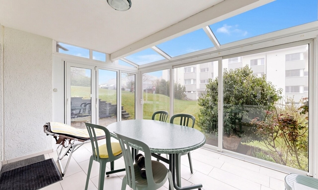 terrace featuring a sunroom and outdoor dining area