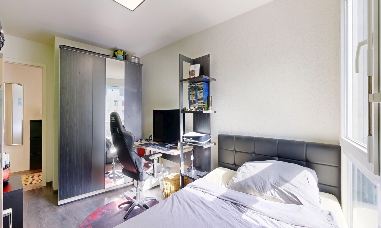 chambre avec télévision, cloison sèche, drywall, inside property, et sol en finition bois