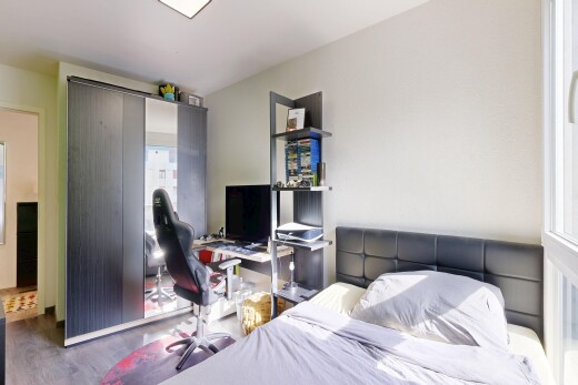 chambre avec télévision, cloison sèche, drywall, inside property, et sol en finition bois