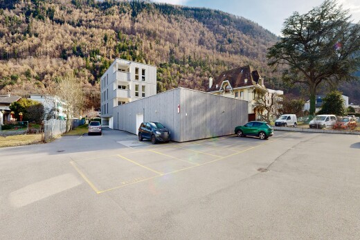 view of property featuring a mountain view, uncovered parking, and a wooded view