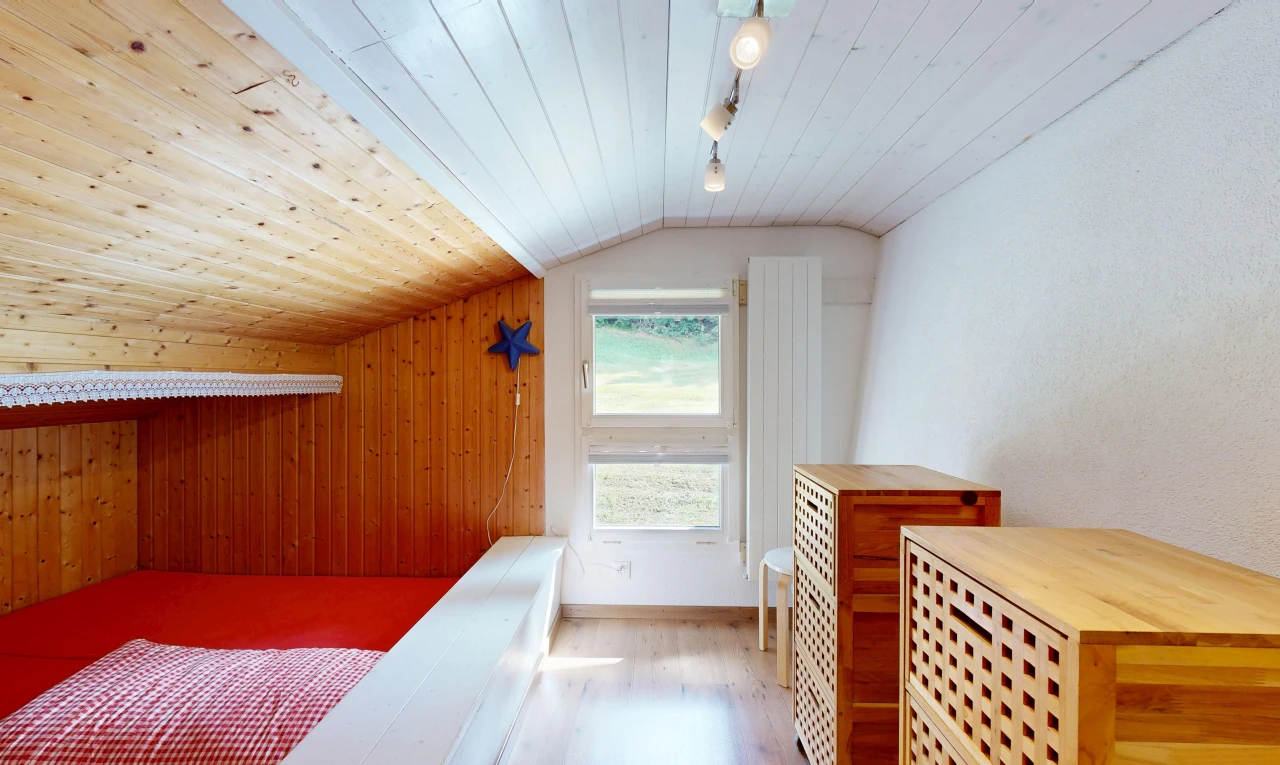 zimmer / schlafzimmer mit deckenbeleuchtung, dachschräge, vaulted ceiling, natürliches licht, und holzwand