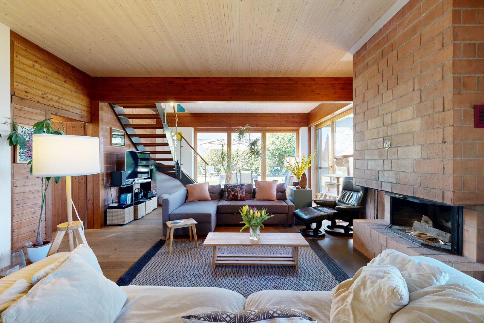 salon avec escaliers, inside property, cheminée, wood finish floor, et sol en finition bois
