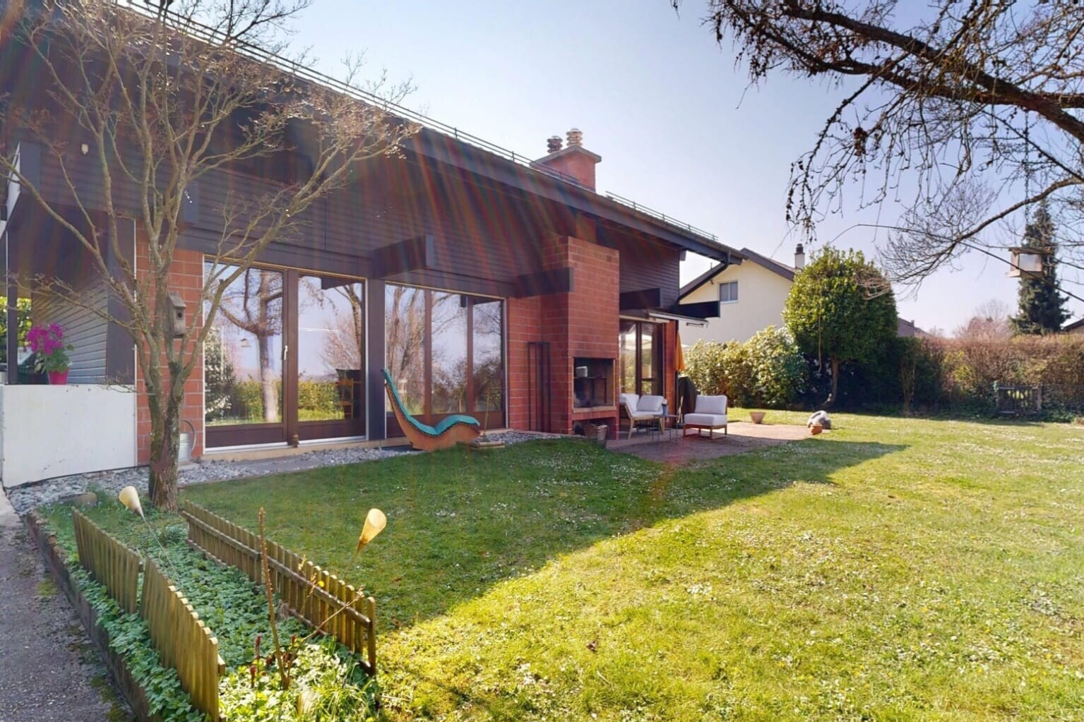 façade avec property visible, pelouse, cheminée, terrasse, et bardage horizontal