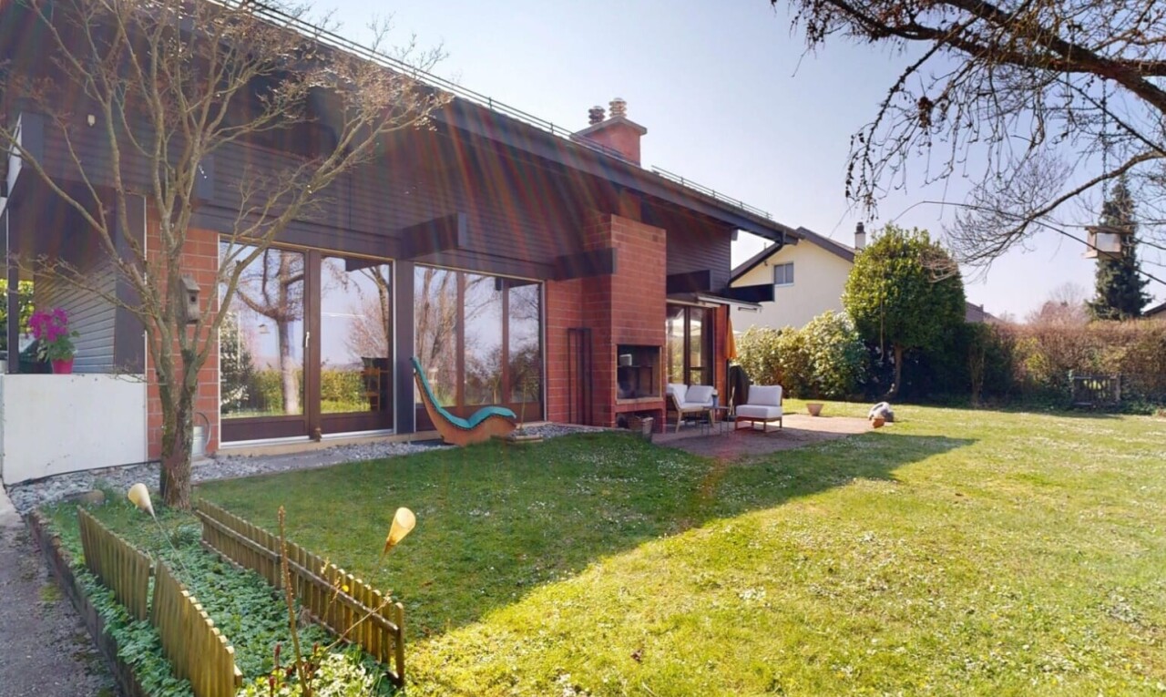 façade avec property visible, pelouse, cheminée, terrasse, et bardage horizontal