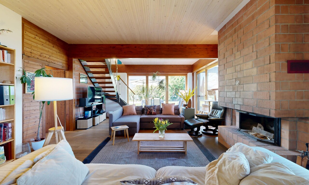 salon avec escaliers, inside property, cheminée, wood finish floor, et sol en finition bois