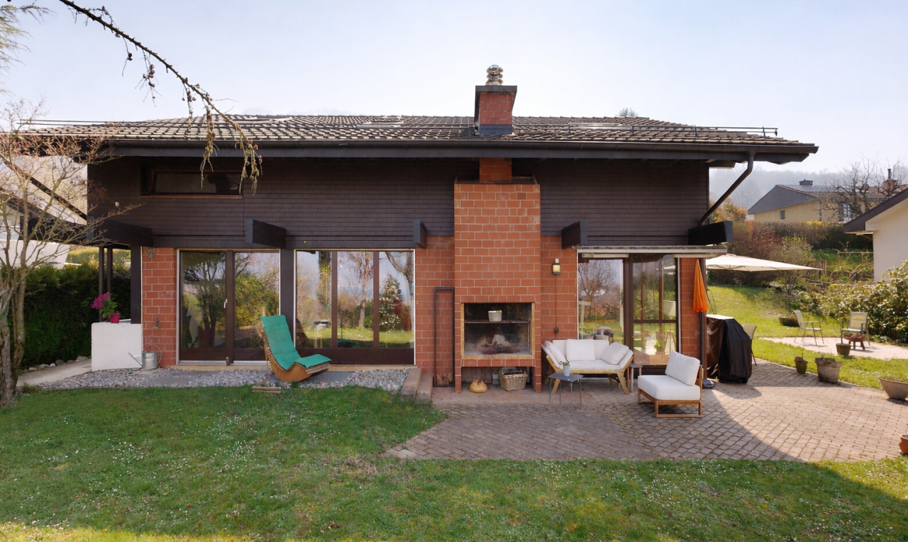 façade avec cheminée, terrasse, pelouse, property visible, et bardage horizontal