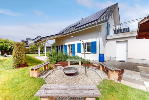 außenansicht mit feuerstelle, solaranlage, property visible, rasen, und day time