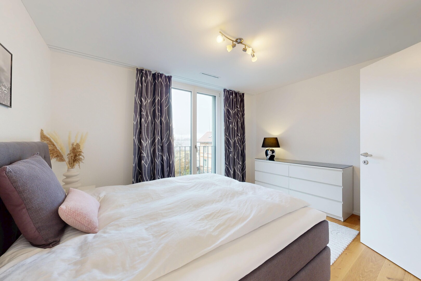 chambre avec cloison sèche, drywall, accès à l'extérieur, sol en finition bois, et wood finish floor