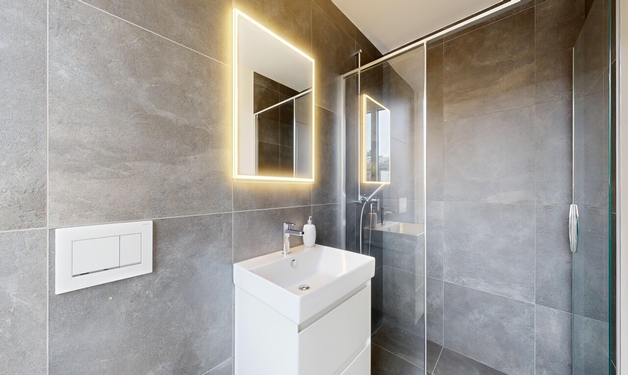 salle de bains avec salle de bain complète, lavabo (ou coiffeuse selon le contexte), douche, miroir, et tile wall