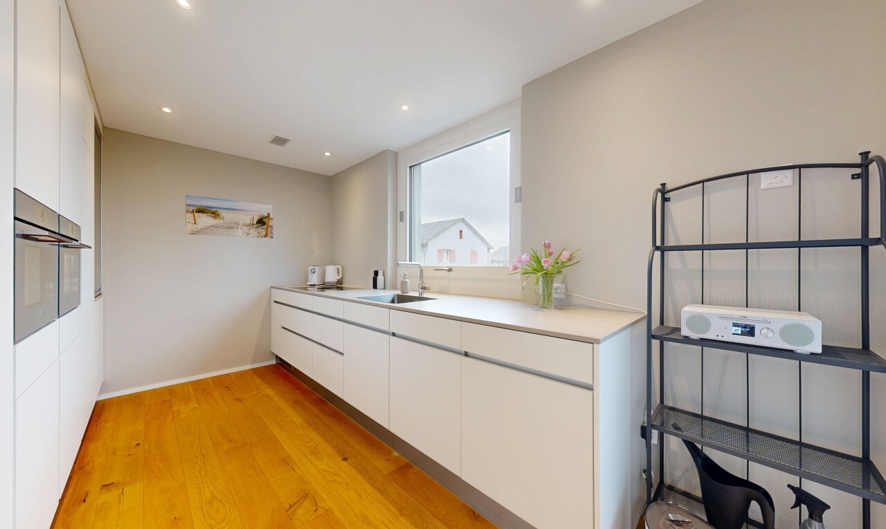 cuisine avec white cabinets, armoires blanches, sol en finition bois, wood finish floor, et light countertops