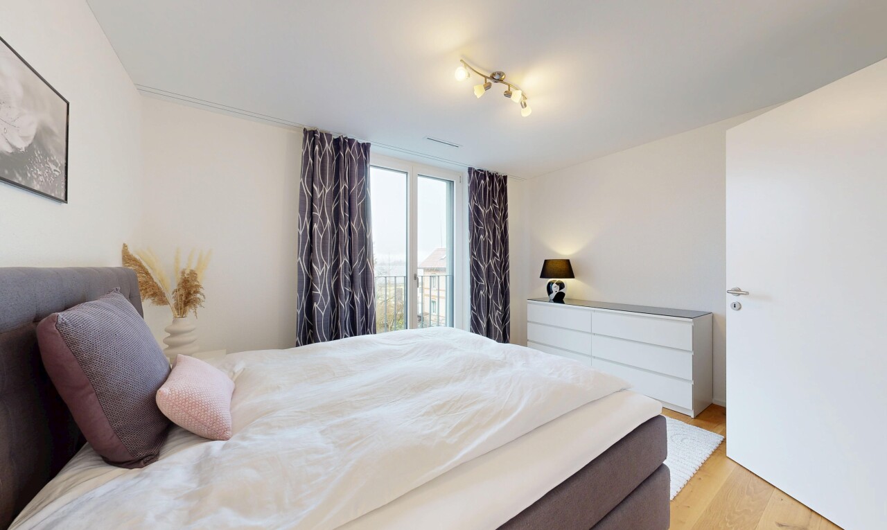 chambre avec cloison sèche, drywall, accès à l'extérieur, sol en finition bois, et wood finish floor