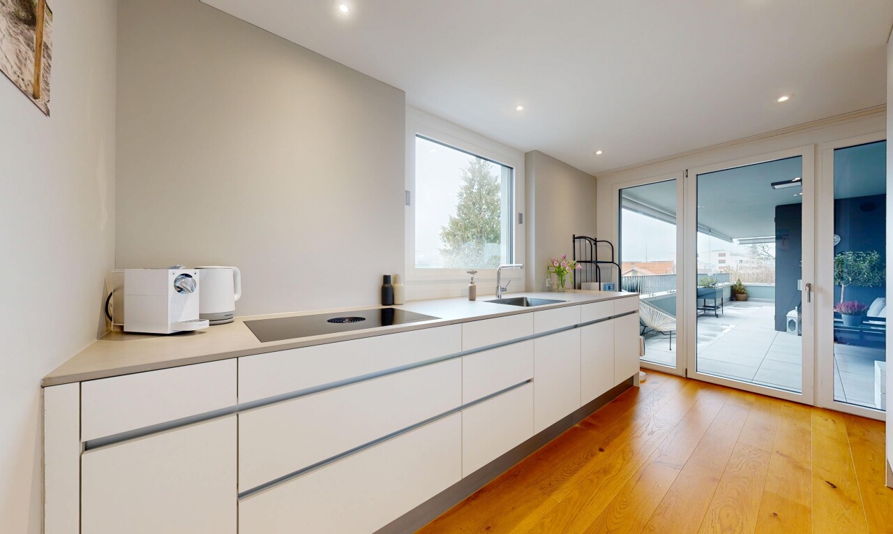 cuisine avec white cabinets, armoires blanches, sol en finition bois, wood finish floor, et flat panel cabinets