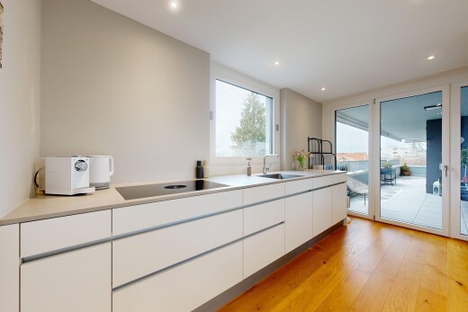 cuisine avec white cabinets, armoires blanches, sol en finition bois, wood finish floor, et flat panel cabinets