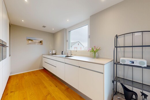 cuisine avec white cabinets, armoires blanches, sol en finition bois, wood finish floor, et light countertops