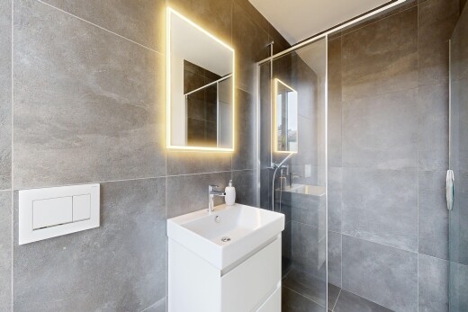 salle de bains avec salle de bain complète, lavabo (ou coiffeuse selon le contexte), douche, miroir, et tile wall