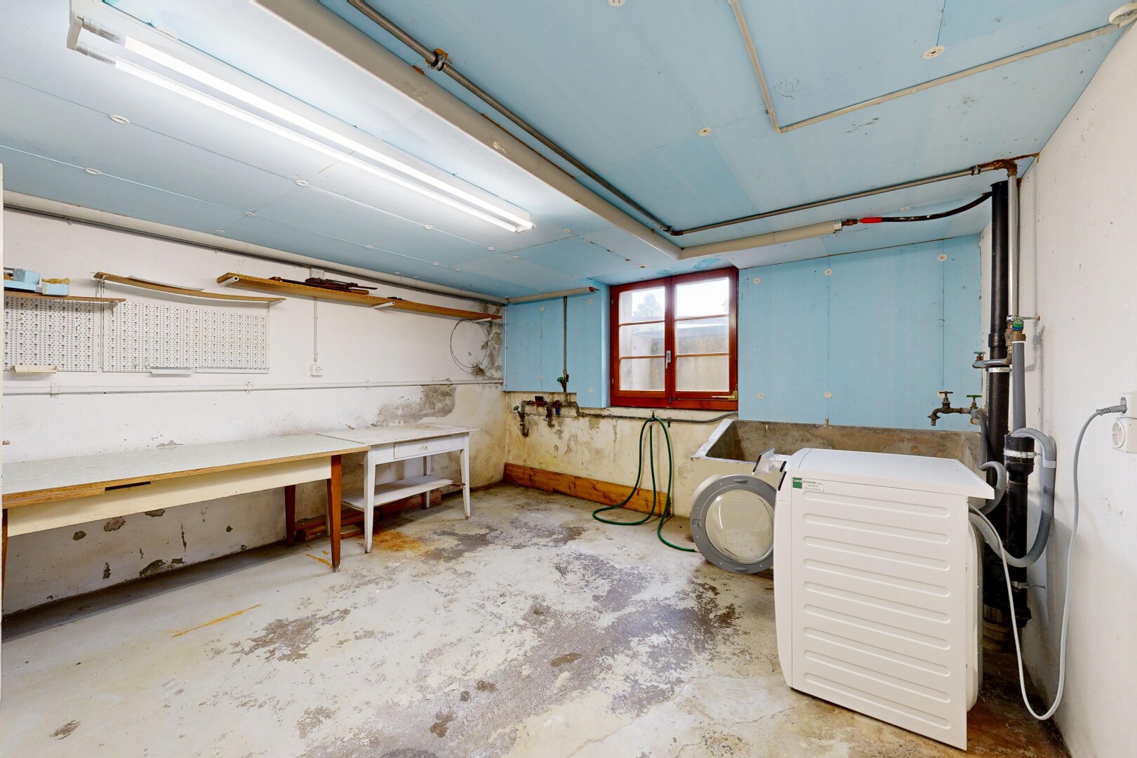 wäschekammer mit betonboden, concrete floor, unfinished concrete floor, inside property, und natürliches licht