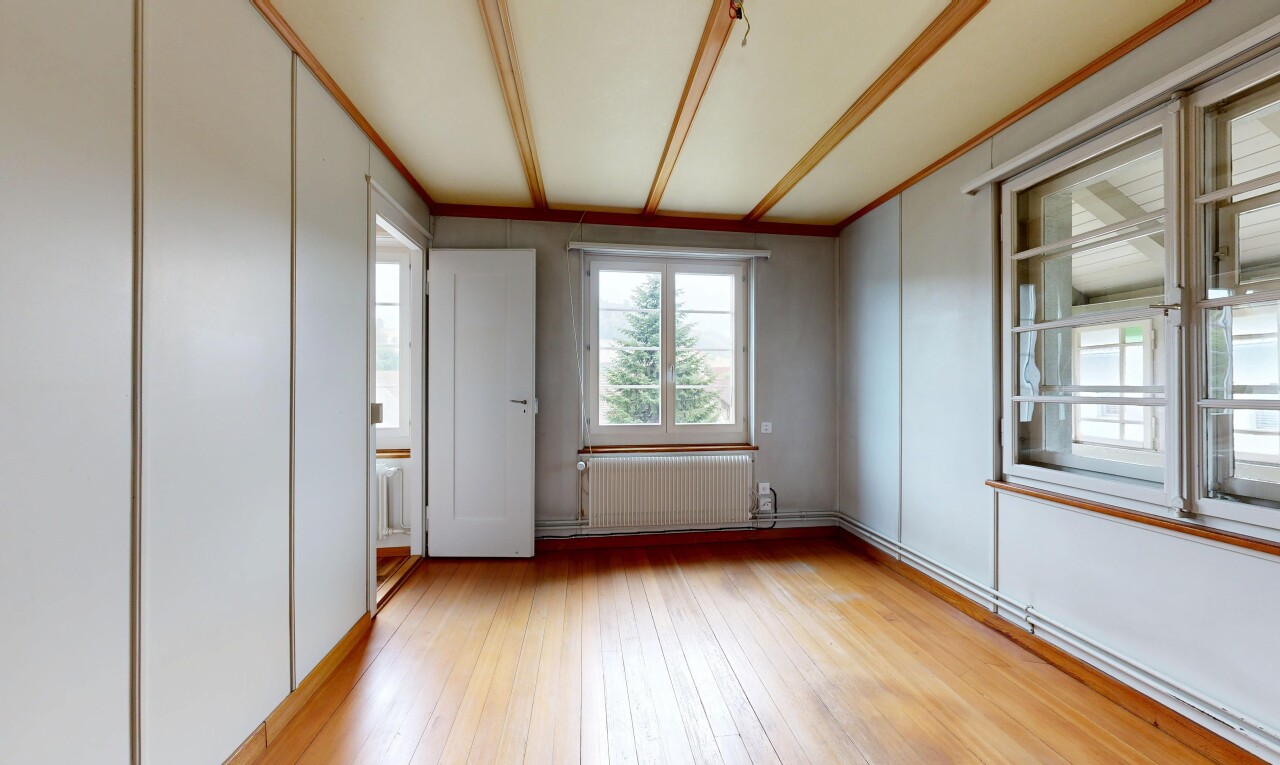 leerer raum mit kühler, natürliches licht, manufactured wall, holzfußboden, und wood finish floor