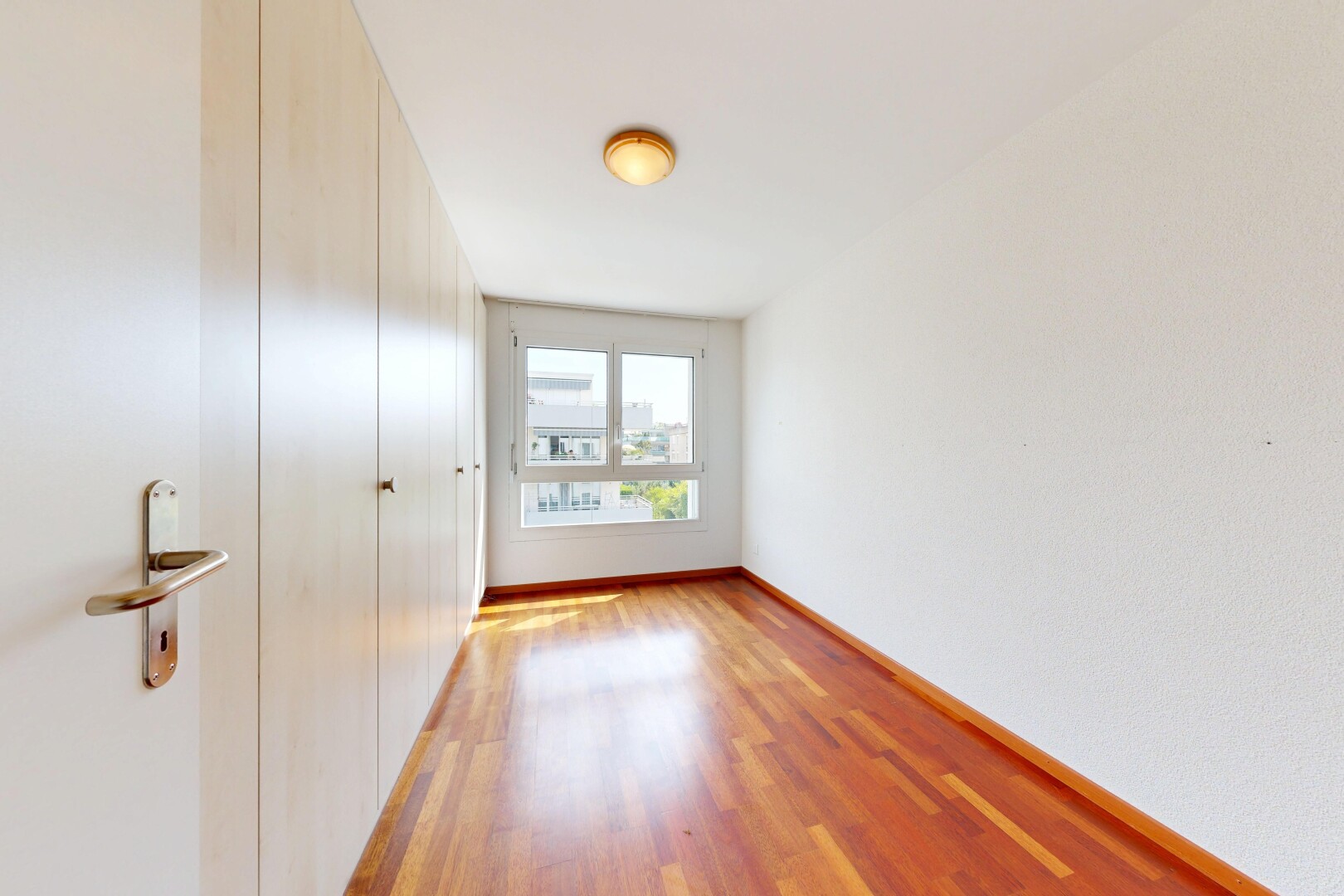 pièce vide avec sol en finition bois, wood finish floor, plinthes murales, baseboards wall, et lumière naturelle