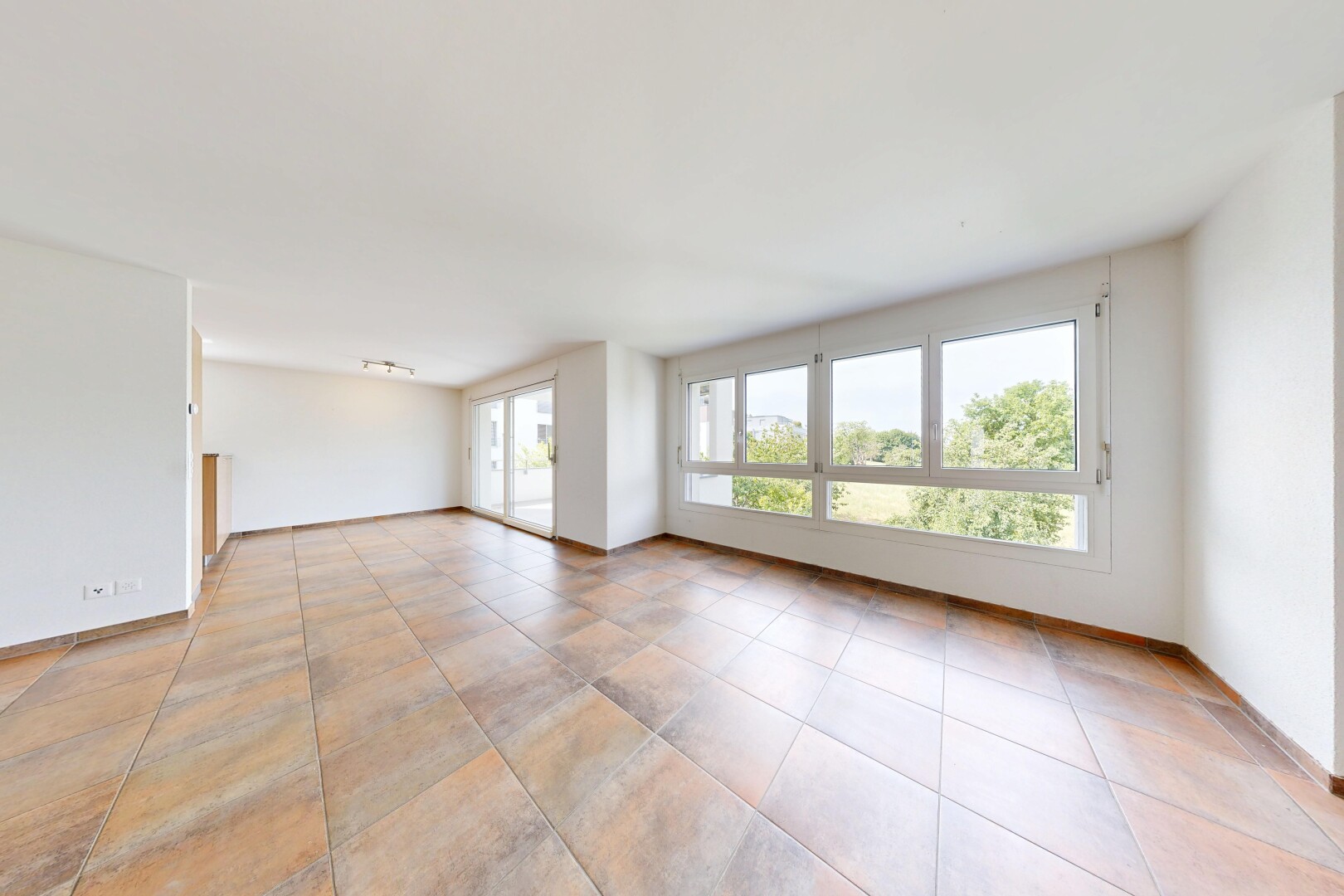 pièce vide avec inside property, light floor, cloison sèche, drywall, et lumière naturelle