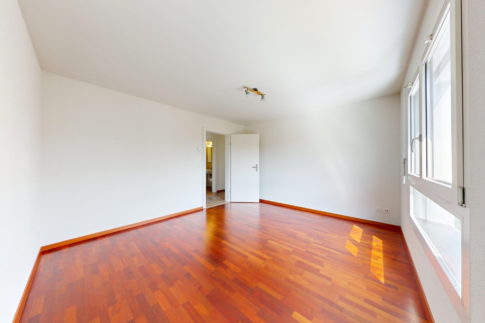 pièce vide avec inside property, sol en finition bois, wood finish floor, cloison sèche, et drywall