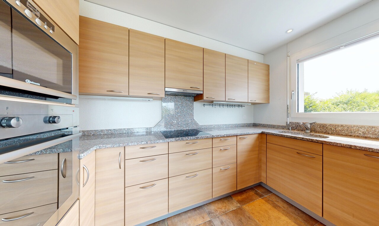 cuisine avec four, light brown cabinets, armoires marron clair, micro-ondes, et stone countertops