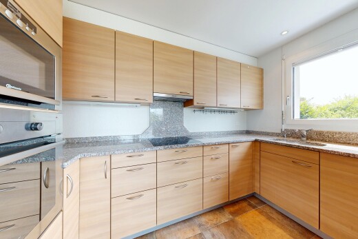 cuisine avec four, light brown cabinets, armoires marron clair, micro-ondes, et stone countertops