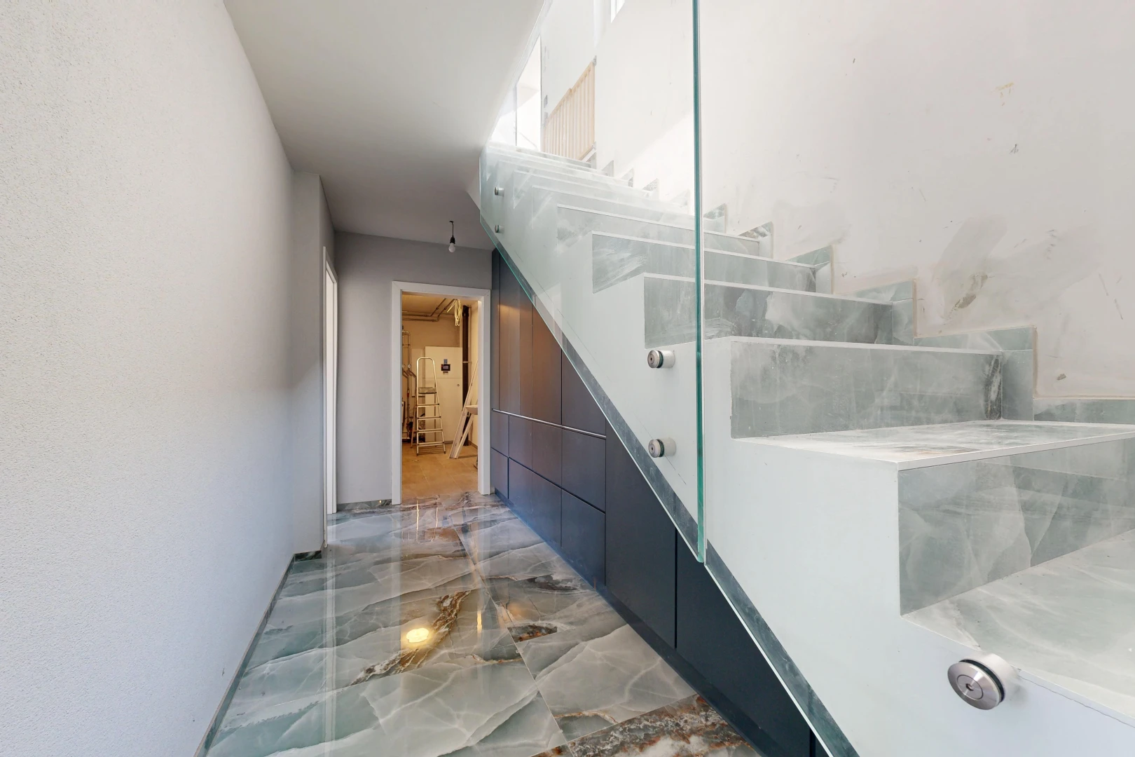 escaliers avec marble finish floor, sol en finition marbre, drywall, cloison sèche, et marble tile