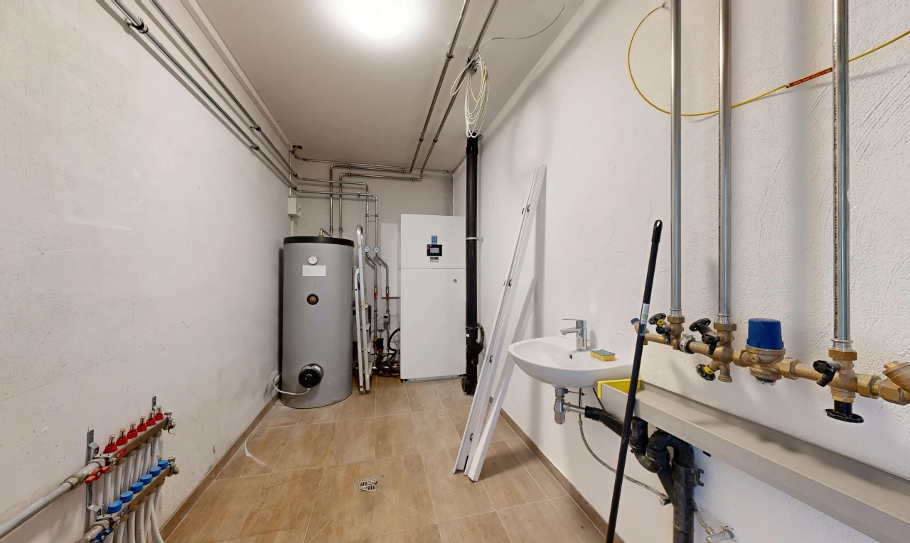 buanderie avec chauffe-eau, inside property, évier, drywall, et cloison sèche