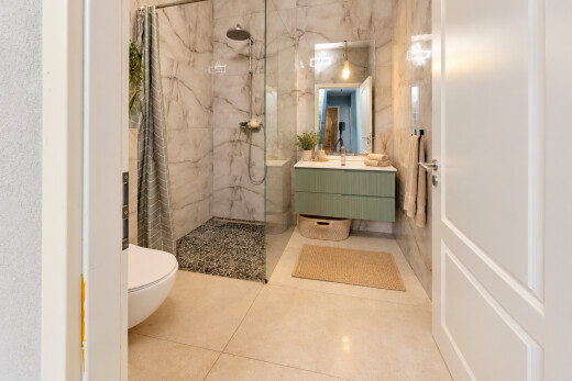 salle de bains avec douche, lavabo (ou coiffeuse selon le contexte), salle de bain complète, toilette, et miroir