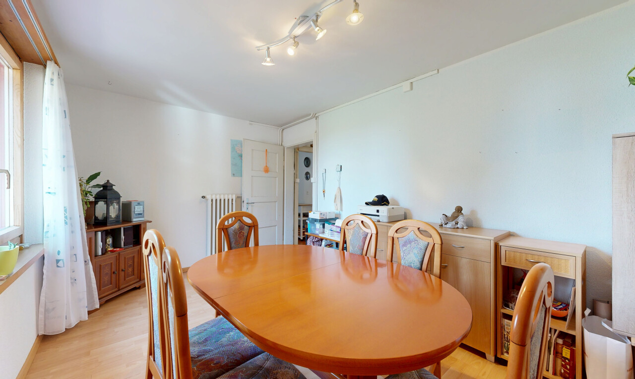 salle à manger avec éclairage sur rail, radiateur, drywall, cloison sèche, et wood finish floor