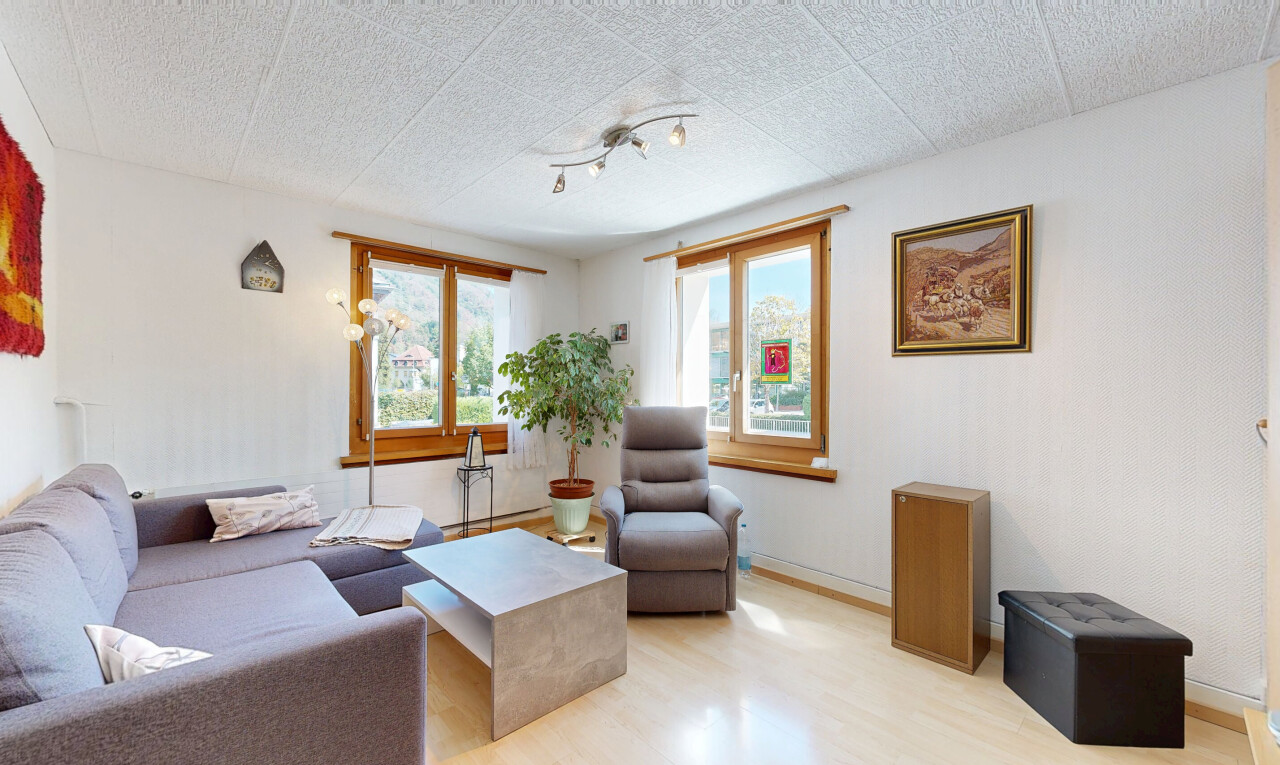 salon avec éclairage sur rail, wood finish floor, sol en finition bois, inside property, et drywall